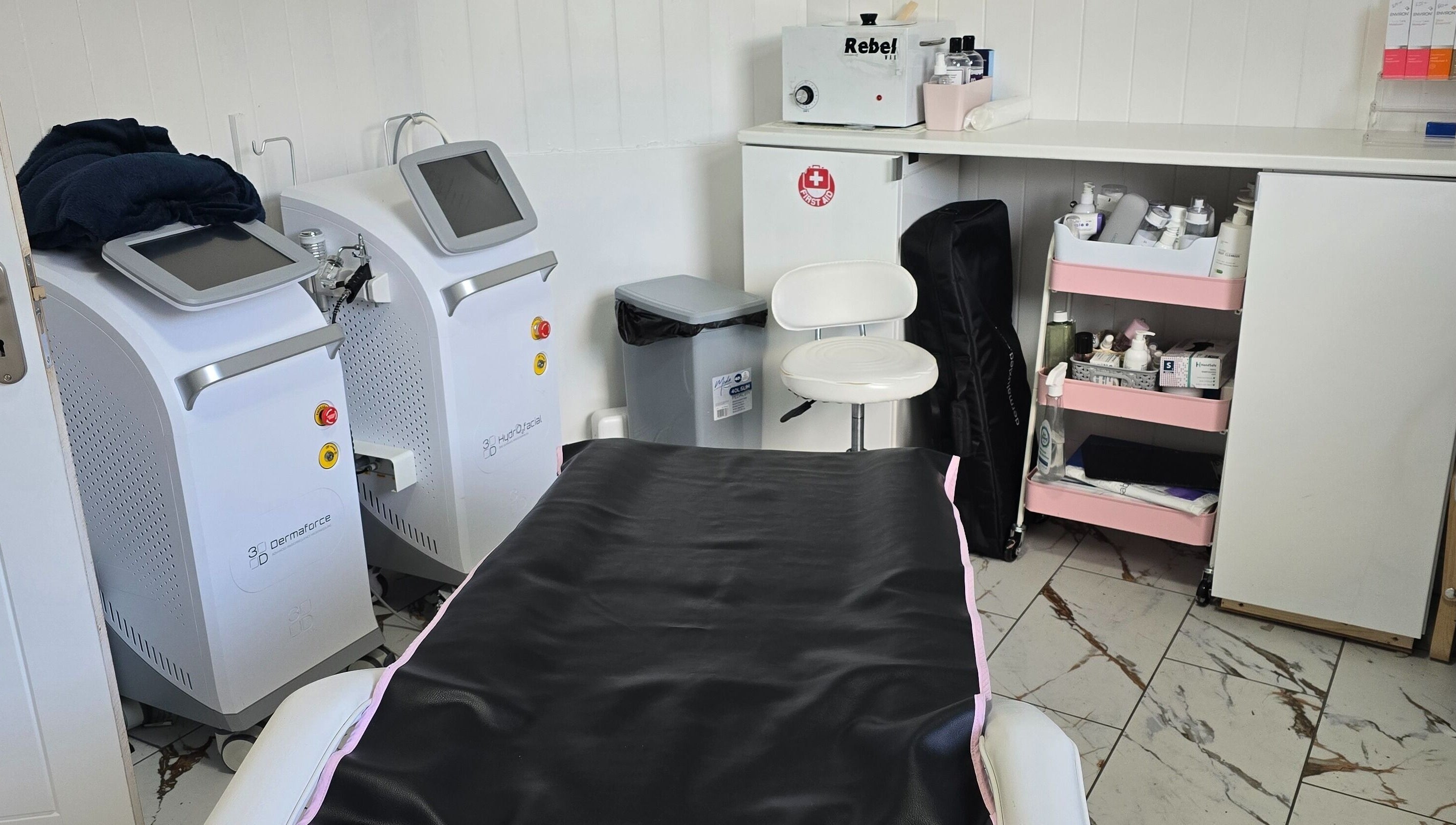 Treatment room at Jane Smith Beauty, Wellingborough, England, GB, featuring modern equipment and organized shelves.
