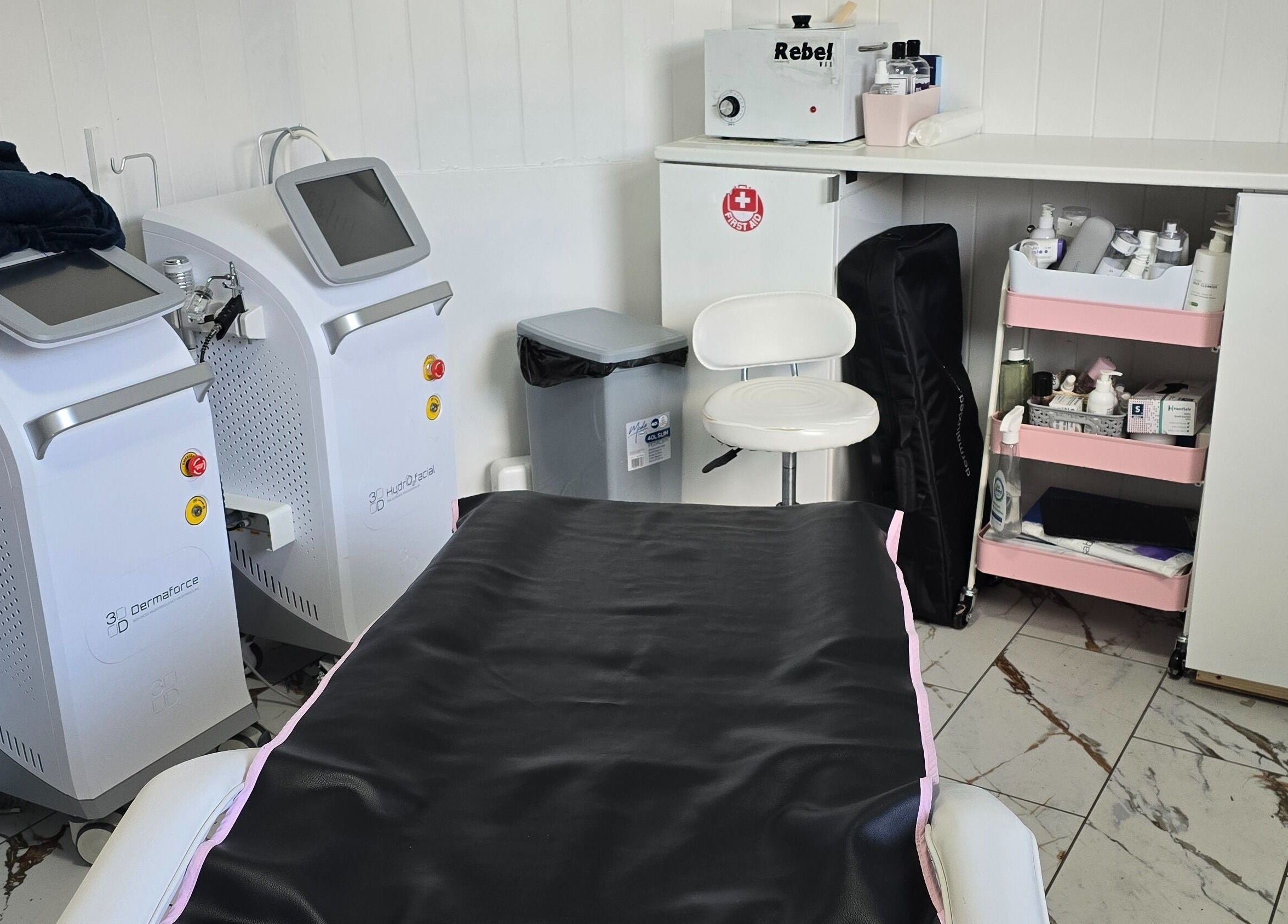 Treatment room at Jane Smith Beauty, Wellingborough, England, GB, featuring modern equipment and organized shelves.