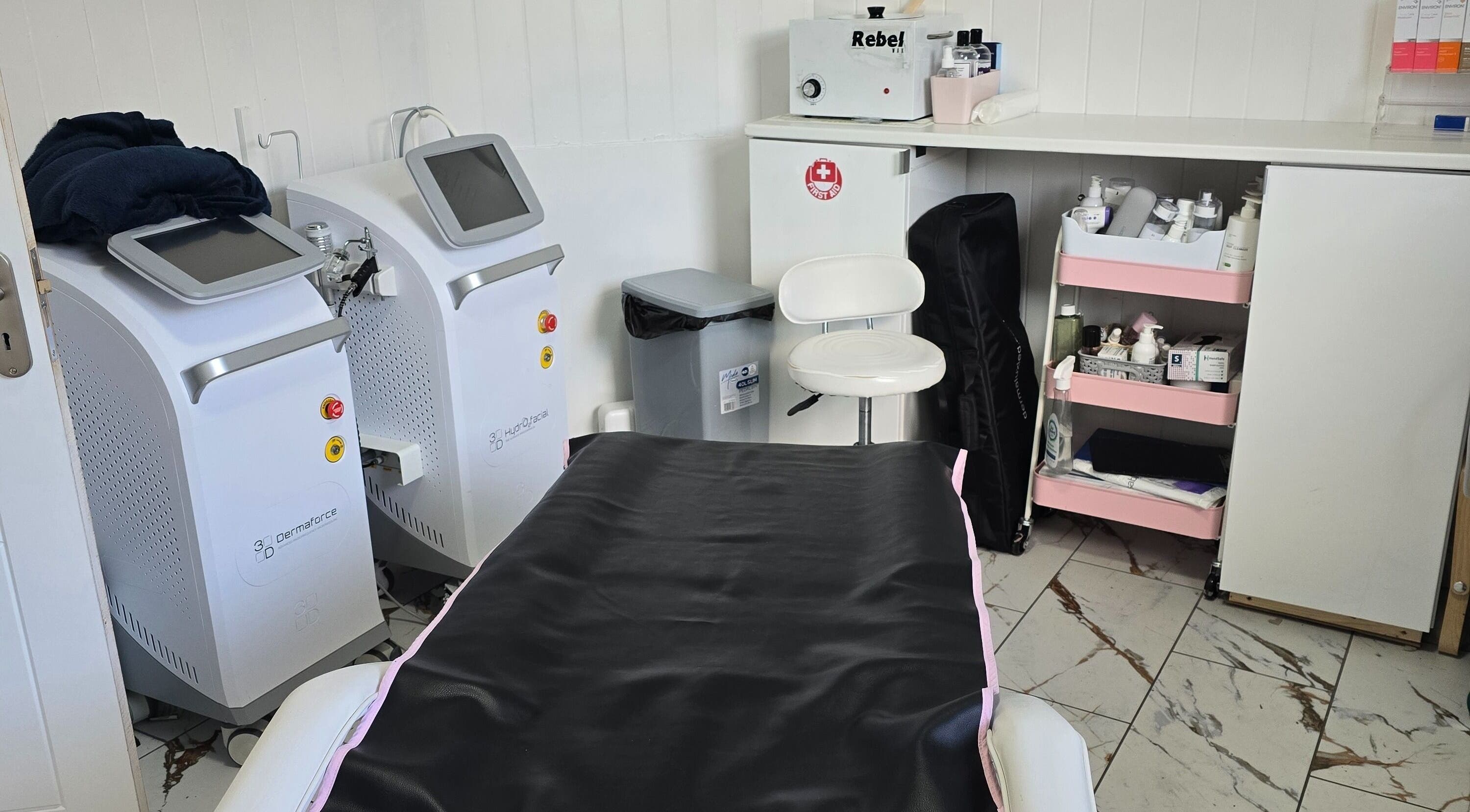 Treatment room at Jane Smith Beauty, Wellingborough, England, GB, featuring modern equipment and organized shelves.