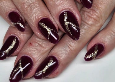 Elegant burgundy nails with gold accents at Nova Nails, Glasgow, Scotland, GB.