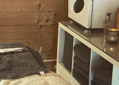 Cozy treatment room at Hygge Beauty Room in West Molesey, England, GB, with warm wooden decor and soft linens.