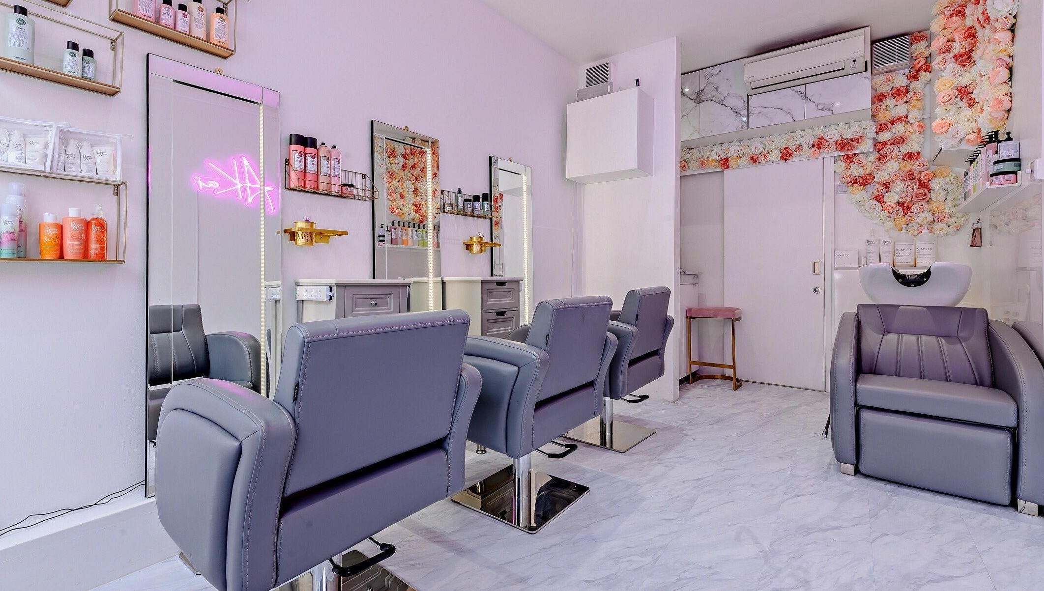 Modern salon interior at AKai, London, England, GB with stylish seating and floral decor.