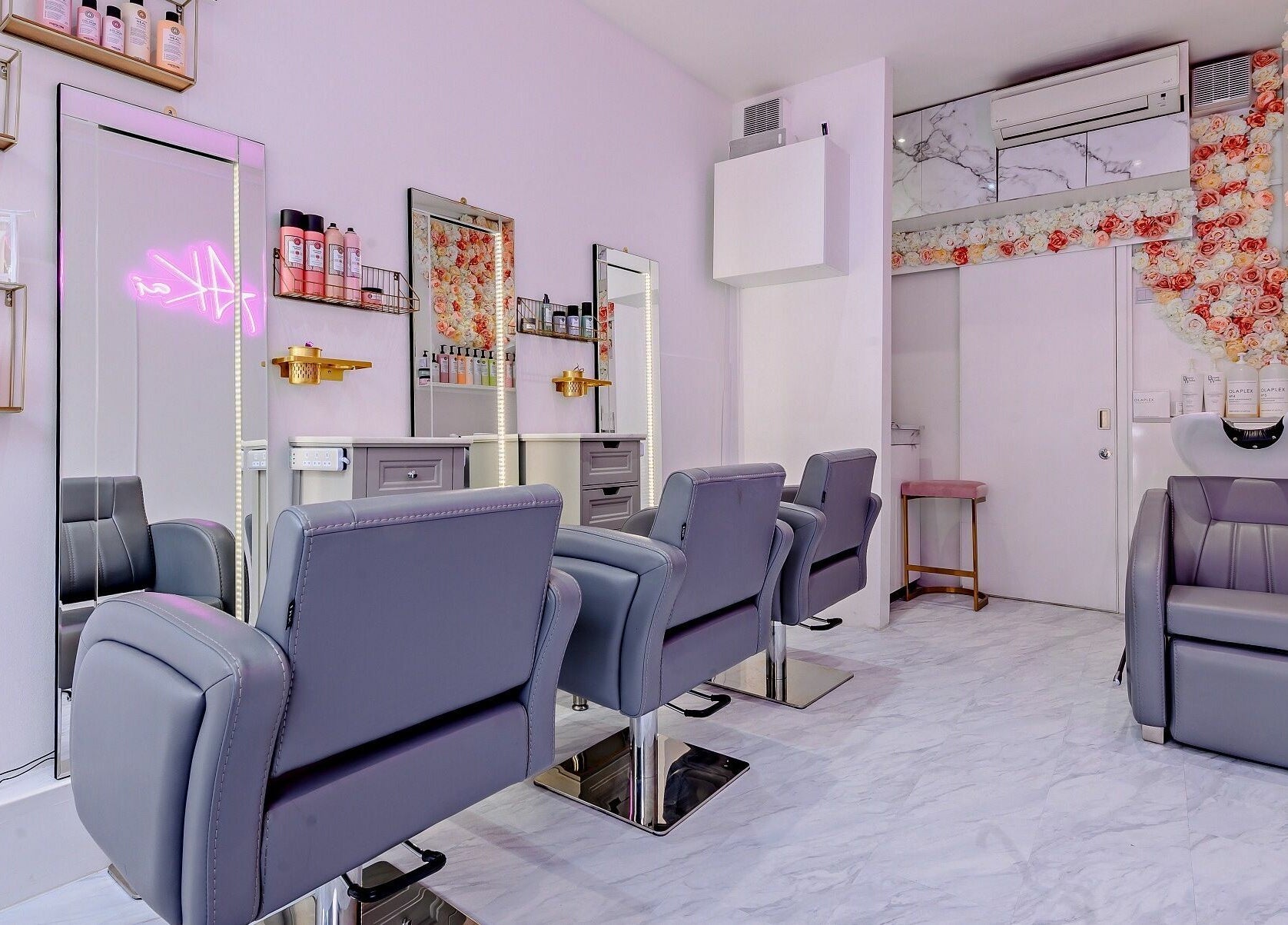 Modern salon interior at AKai, London, England, GB with stylish seating and floral decor.