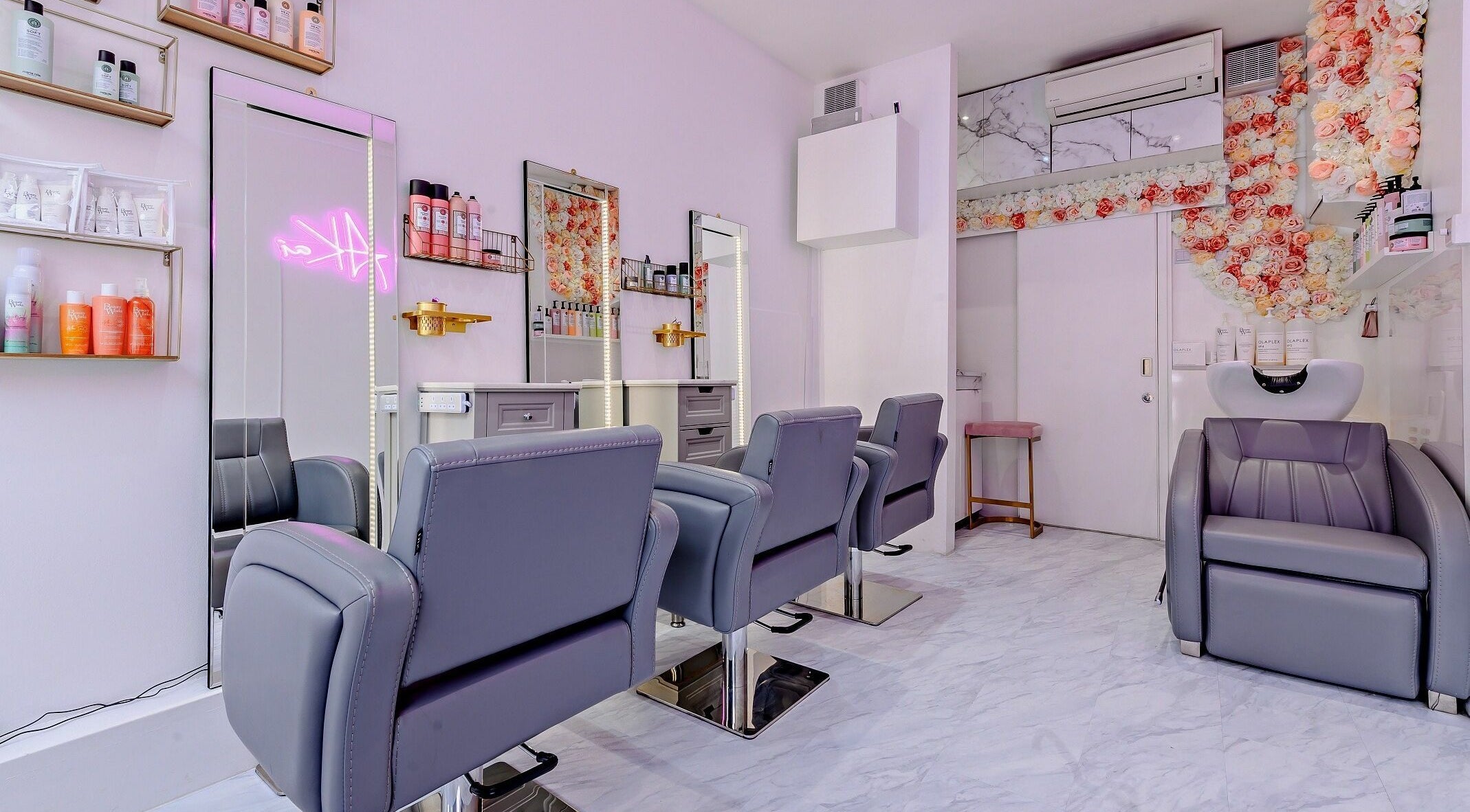 Modern salon interior at AKai, London, England, GB with stylish seating and floral decor.