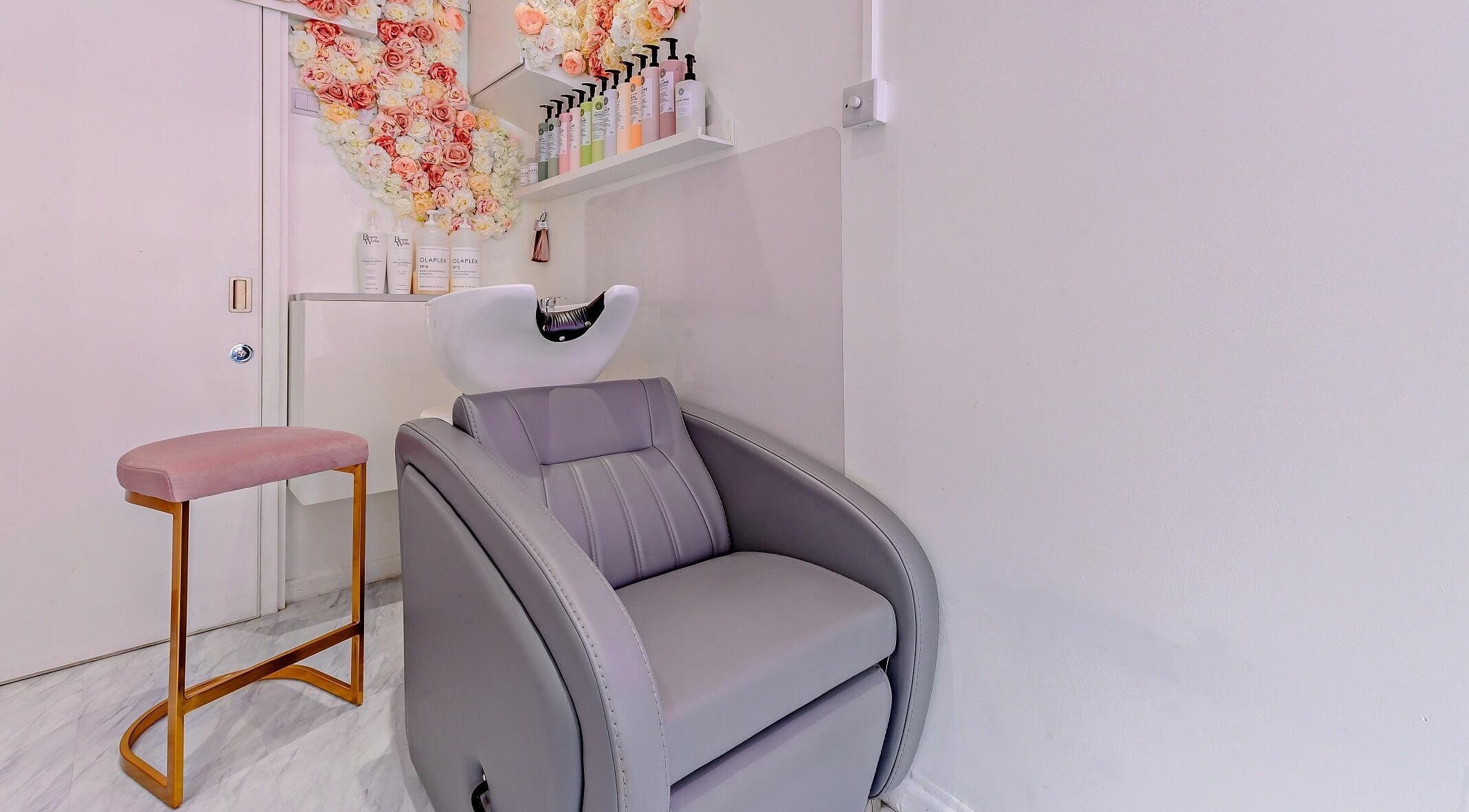 Elegant salon hair wash station with plush chair at AKai, London, England, GB, adorned with floral decor.