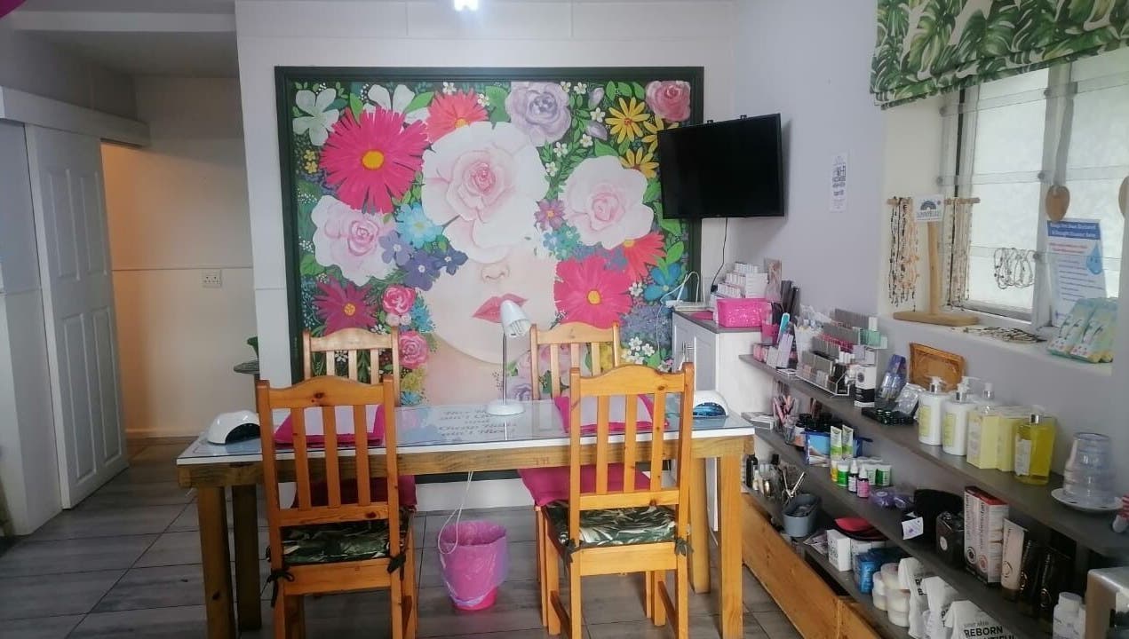 Pop in Beauty Bar, Saint Francis Bay, ZA: vibrant floral mural and cozy setup for beauty treatments.
