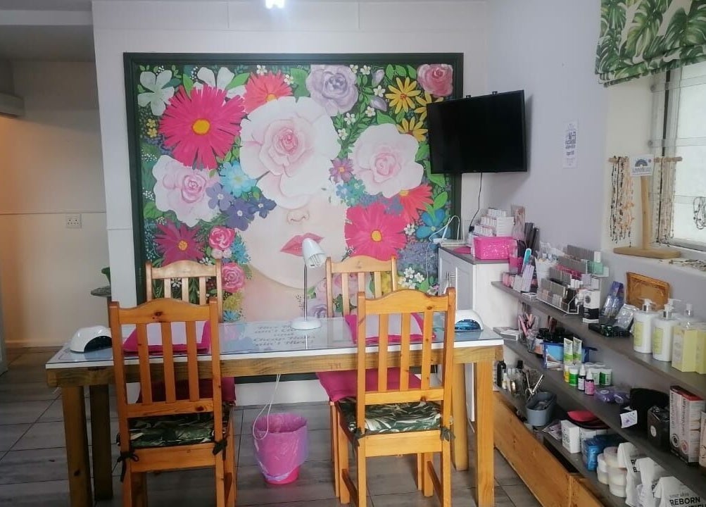 Pop in Beauty Bar, Saint Francis Bay, ZA: vibrant floral mural and cozy setup for beauty treatments.