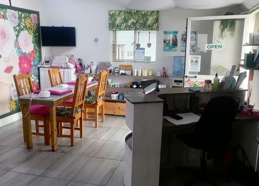 Inviting interior of Pop in Beauty Bar in Saint Francis Bay, ZA with floral decor and cozy seating.