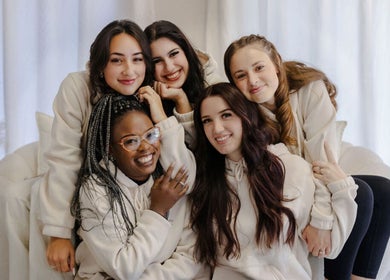 Group of smiling women at Fix Her Crown, Benoni, Gauteng, ZA, enjoying a cozy, relaxed setting.