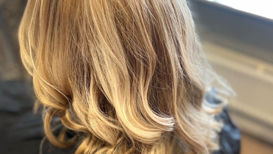Elegant blonde wavy hairstyle at Liam Dawson Hair, Betherson, England, GB.