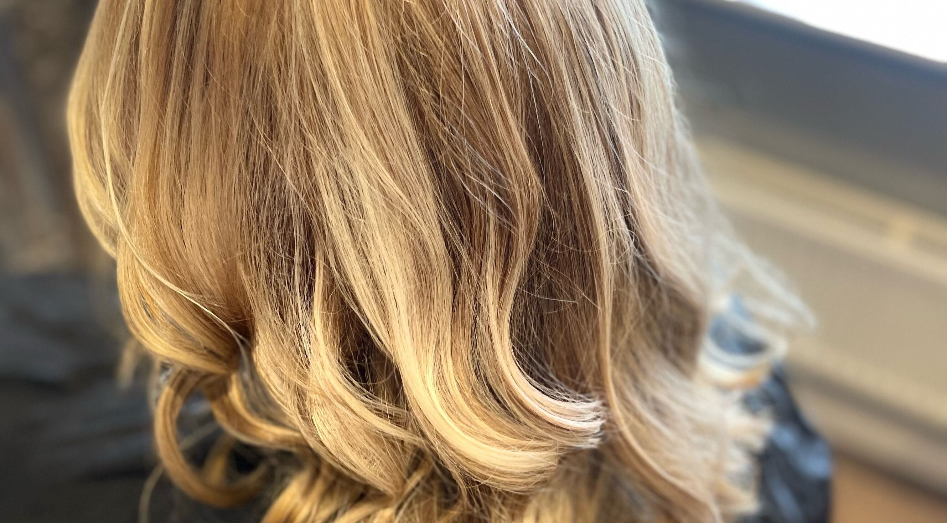 Elegant blonde wavy hairstyle at Liam Dawson Hair, Betherson, England, GB.