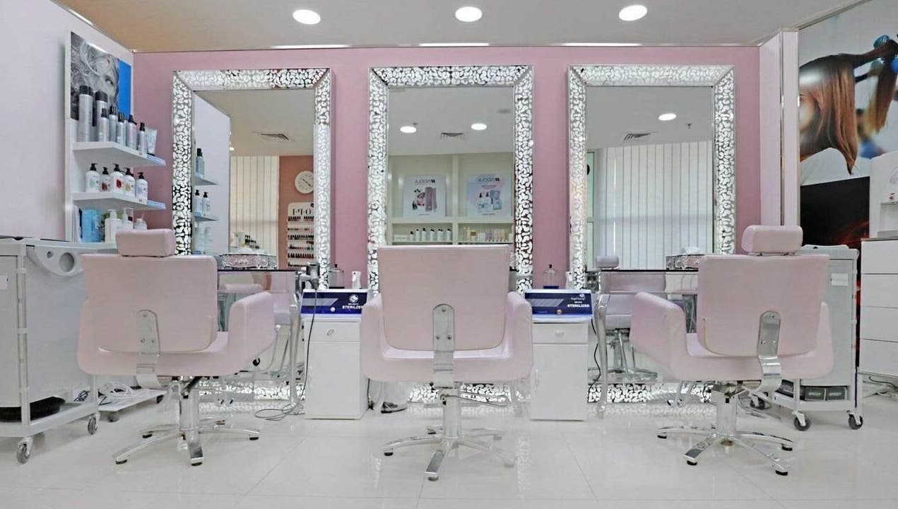 Elegant salon interior at Cleopatra Beauty Salon & Spa, Dubai, Dubai, AE, featuring chic pink chairs and mirrors.