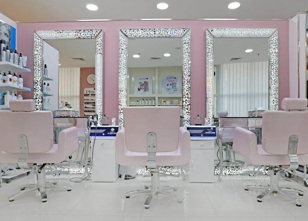 Elegant salon interior at Cleopatra Beauty Salon & Spa, Dubai, Dubai, AE, featuring chic pink chairs and mirrors.