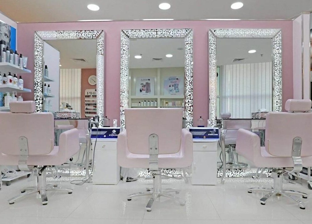 Elegant salon interior at Cleopatra Beauty Salon & Spa, Dubai, Dubai, AE, featuring chic pink chairs and mirrors.