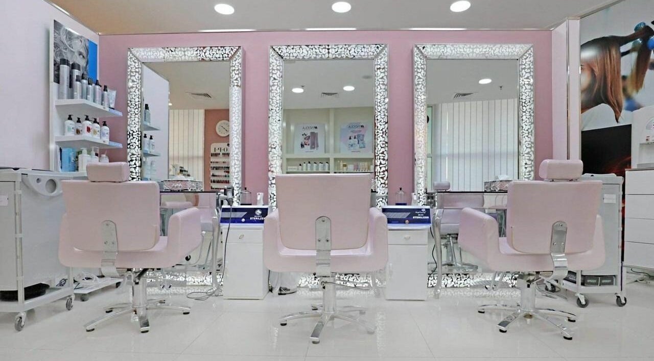Elegant salon interior at Cleopatra Beauty Salon & Spa, Dubai, Dubai, AE, featuring chic pink chairs and mirrors.