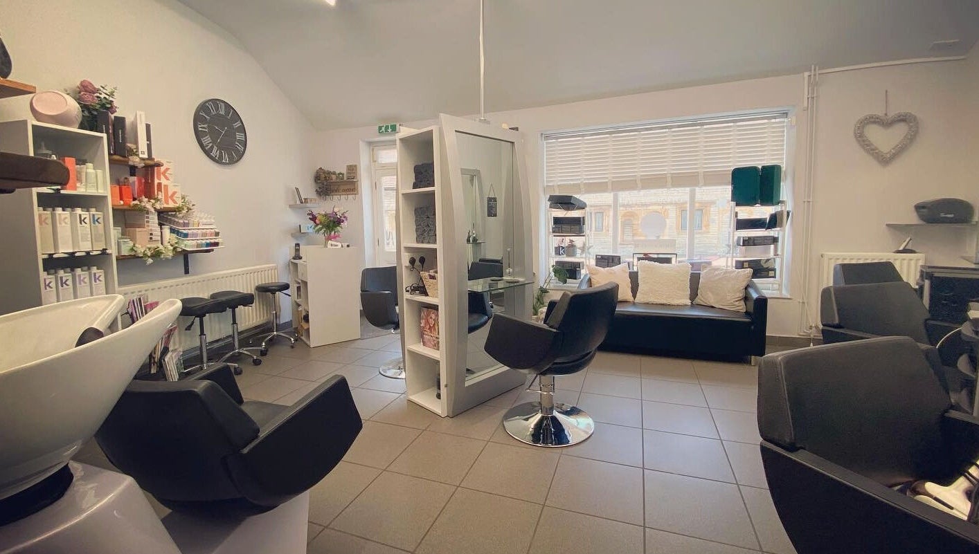 House of Hair salon interior in Somerton, England, GB showcasing modern chairs and products.
