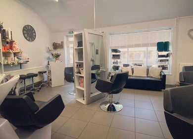House of Hair salon interior in Somerton, England, GB showcasing modern chairs and products.