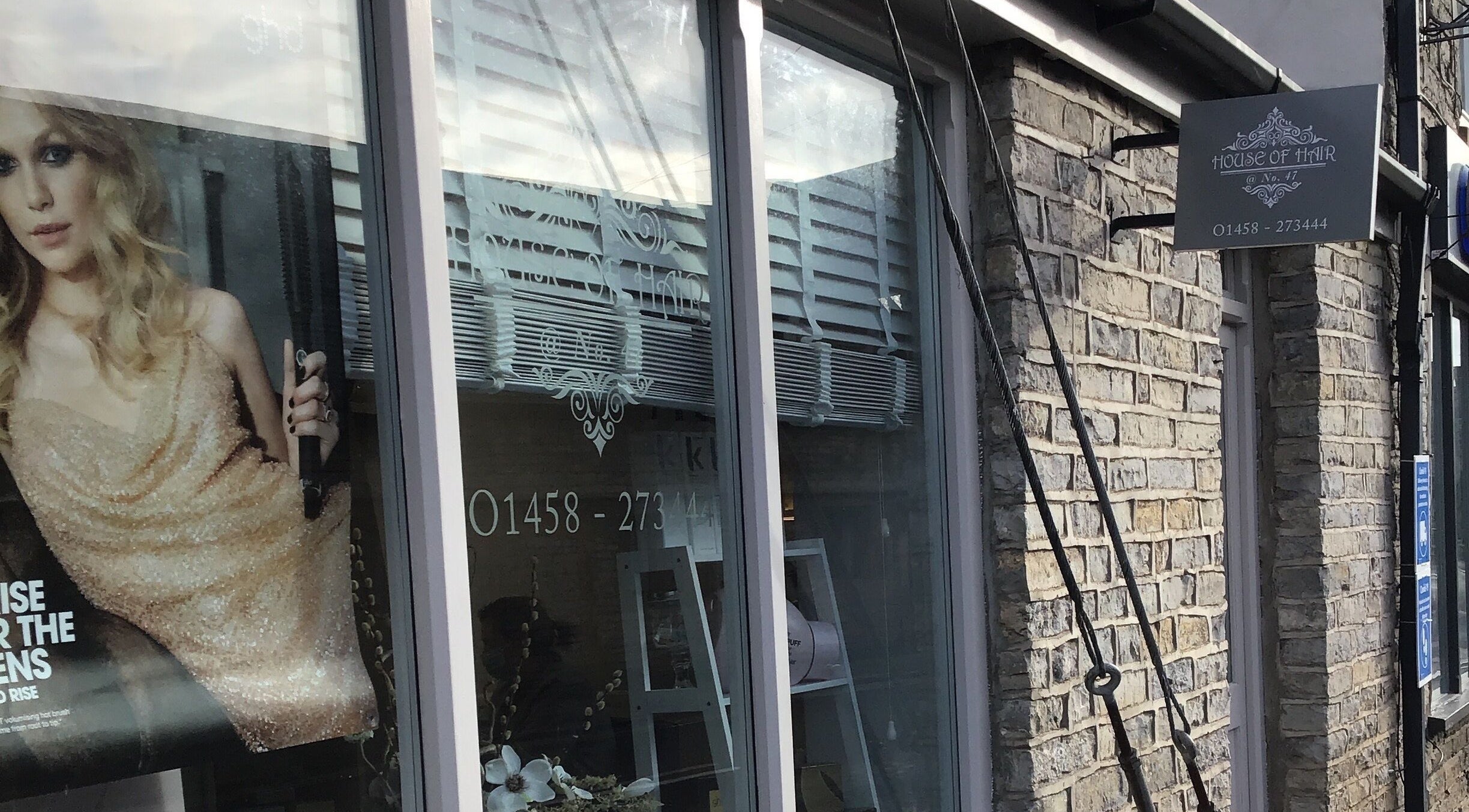 Front view of House of Hair in Somerton, England, featuring elegant signage and stylish window display.