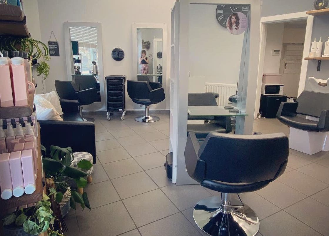 Modern salon chairs and styling stations at House of Hair, Somerton, England, GB, offering a sleek experience.