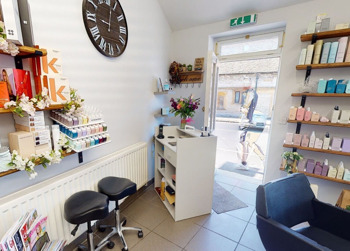 Cozy reception area in House of Hair, Somerton, England, GB with vibrant products and seating.