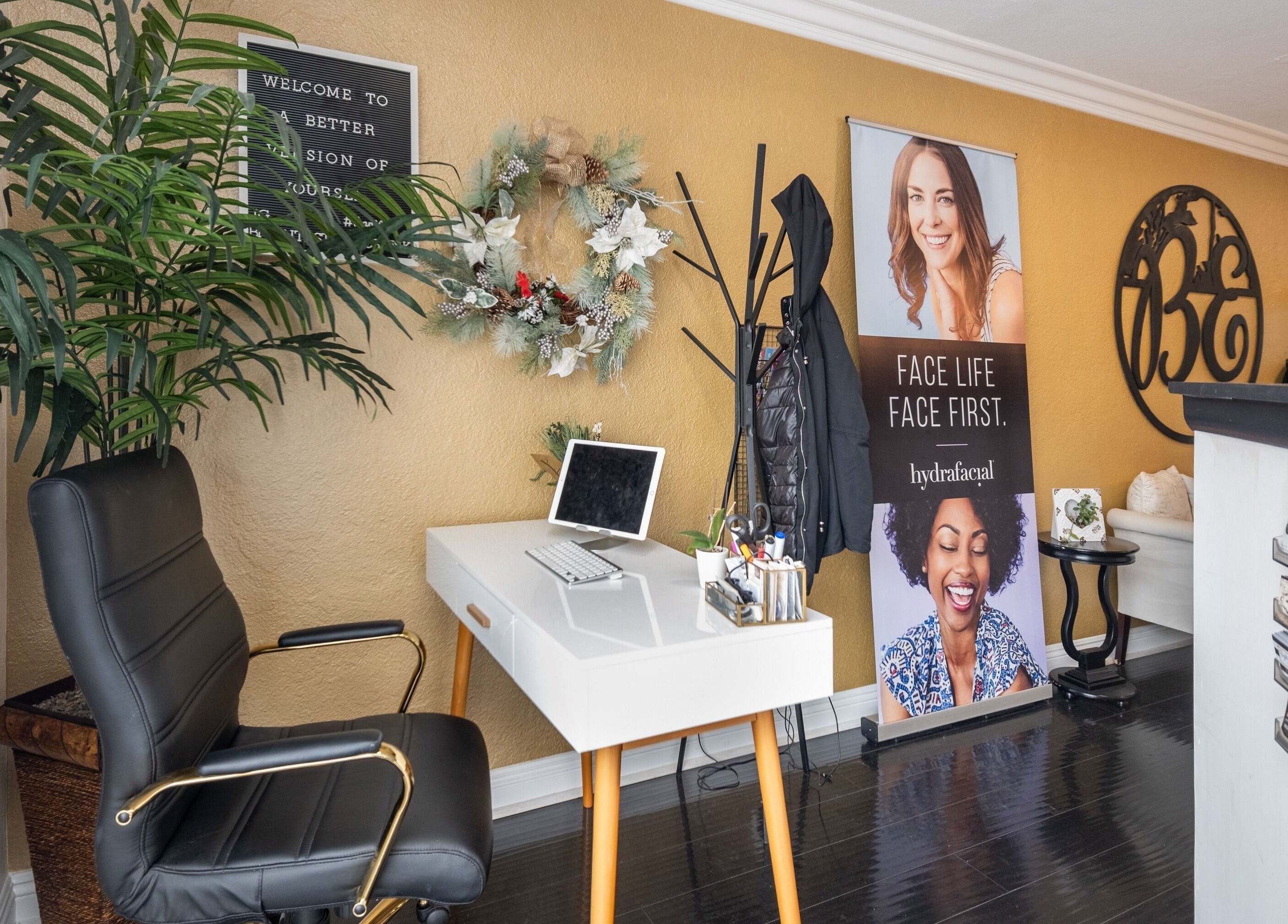 Bright Esthetics reception in Yucaipa, California, features a stylish decor with a sleek desk and indoor plants.