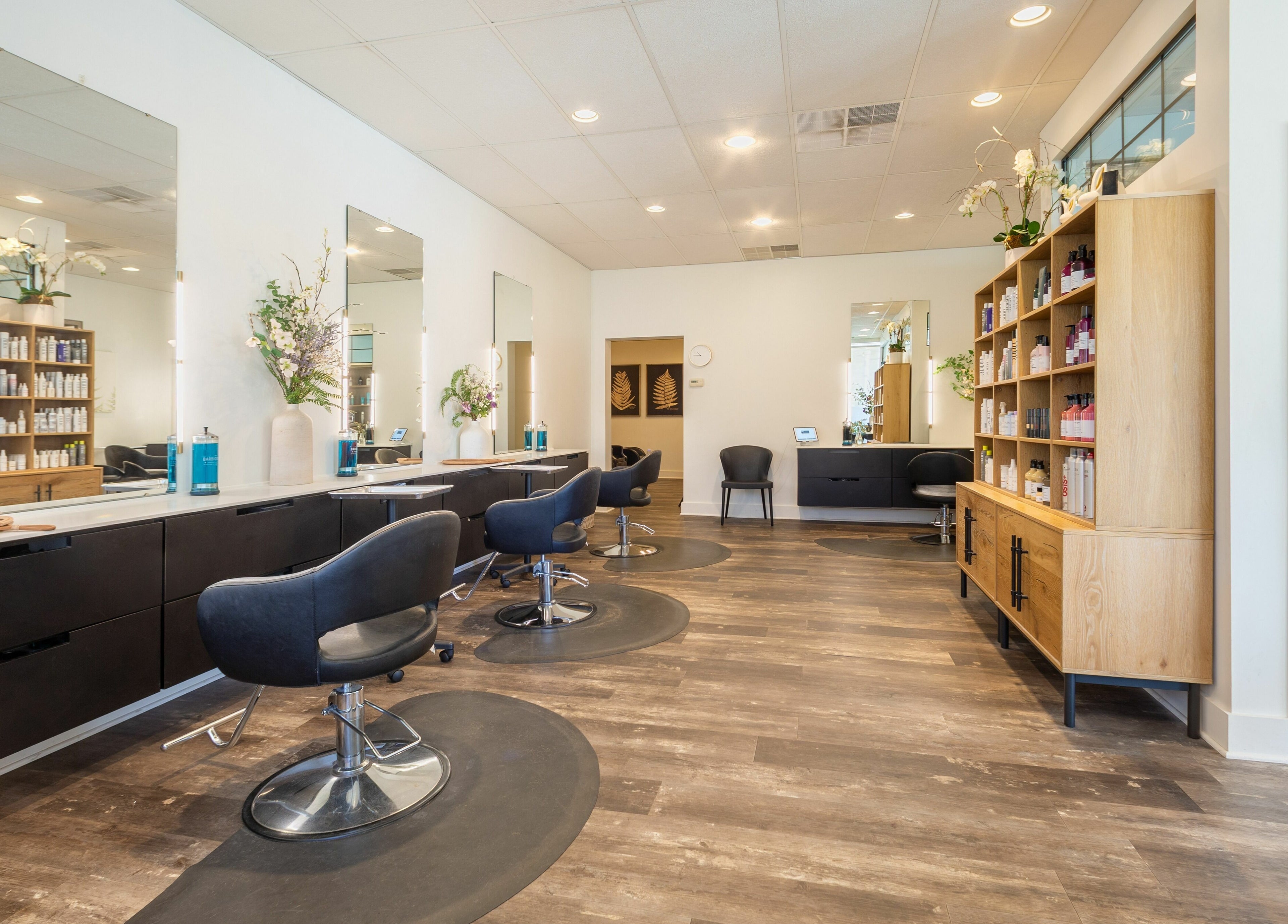 Elegant interior of Salon Bloom Color and Co. in Glenshaw, Pennsylvania, US with stylish black chairs and mirrors.