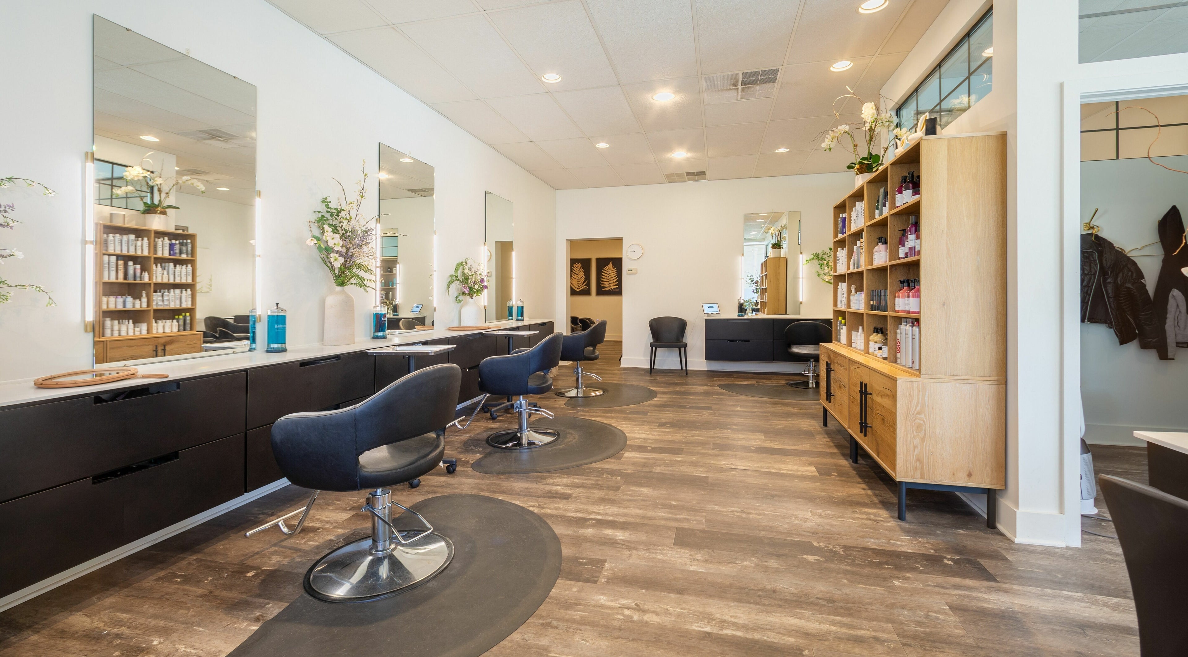 Elegant interior of Salon Bloom Color and Co. in Glenshaw, Pennsylvania, US with stylish black chairs and mirrors.