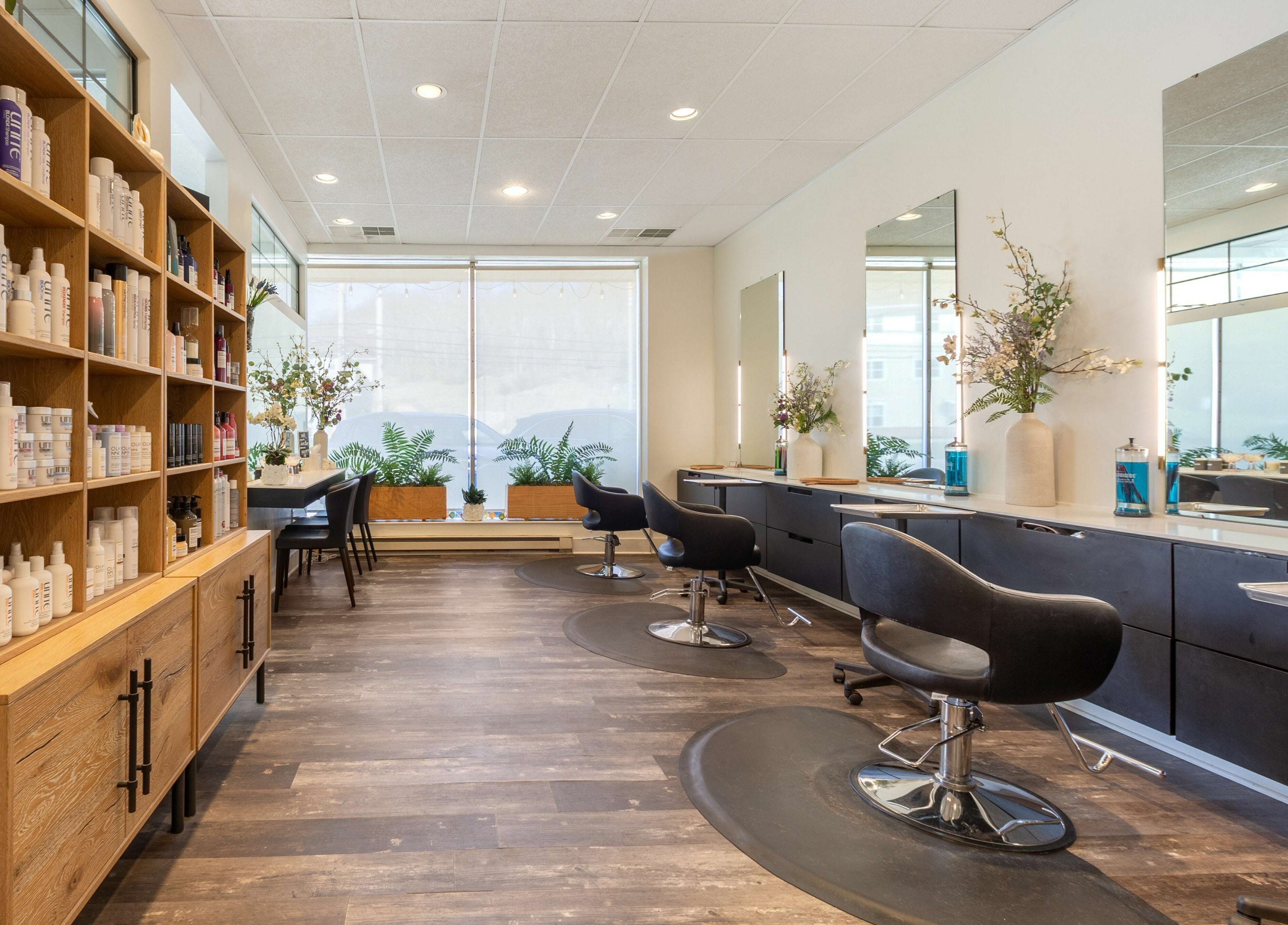 Modern interior of Salon Bloom Color and Co. in Glenshaw, Pennsylvania, US with stylish chairs and beauty products.