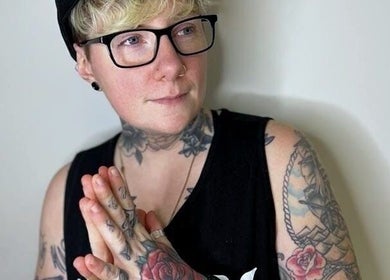 Tattooed individual striking a contemplative pose at New Street Collective, Bridge Of Allan, Scotland, GB.
