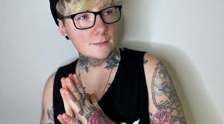 Tattooed individual striking a contemplative pose at New Street Collective, Bridge Of Allan, Scotland, GB.