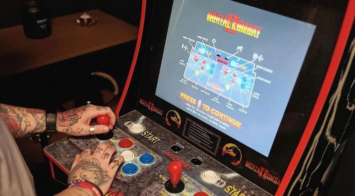 Hands playing Mortal Kombat II arcade game at New Street Collective, Bridge Of Allan, Scotland, GB.