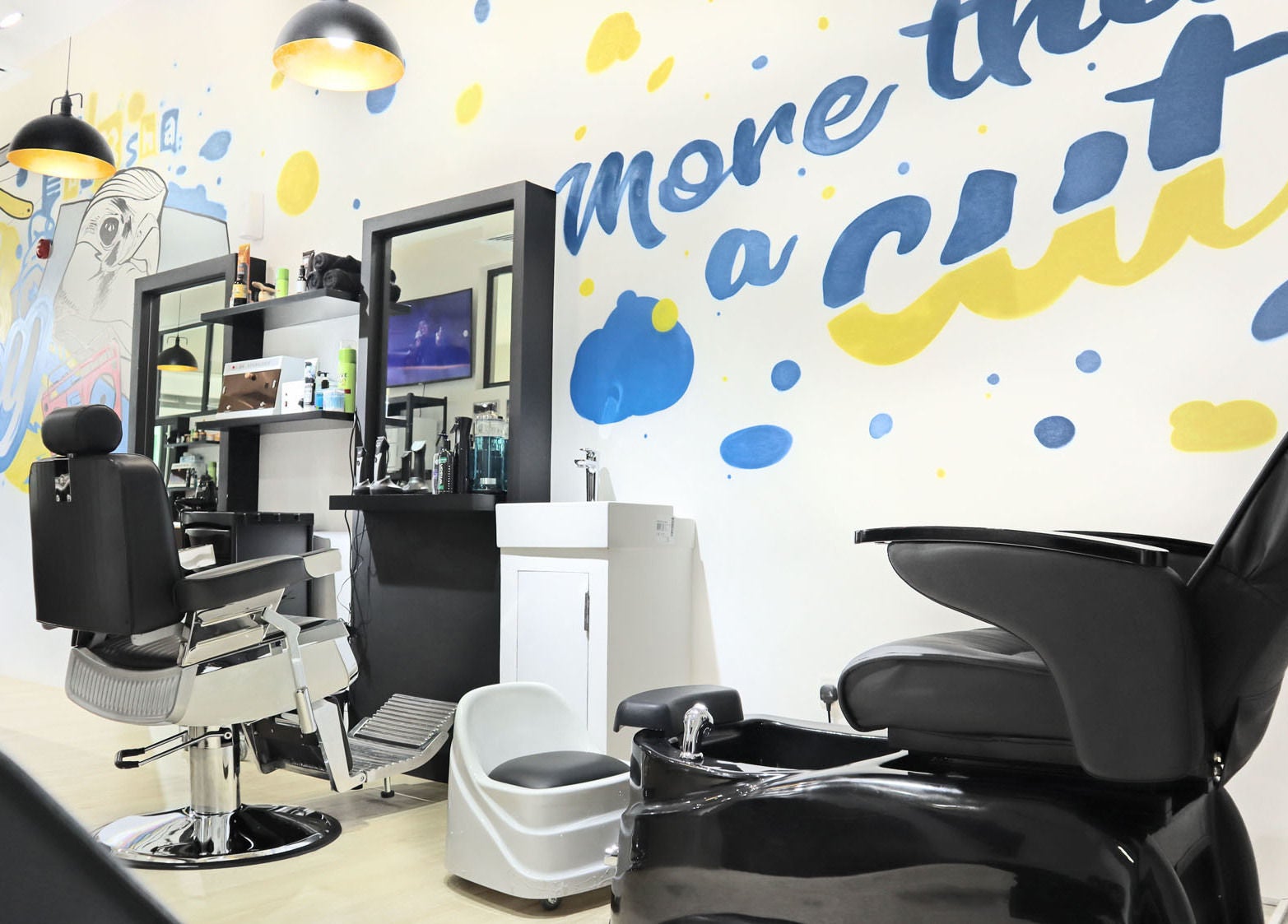 Interior of Fade & Play - Al Barsha, Dubai, showcasing modern barbershop chairs and artistic wall design.