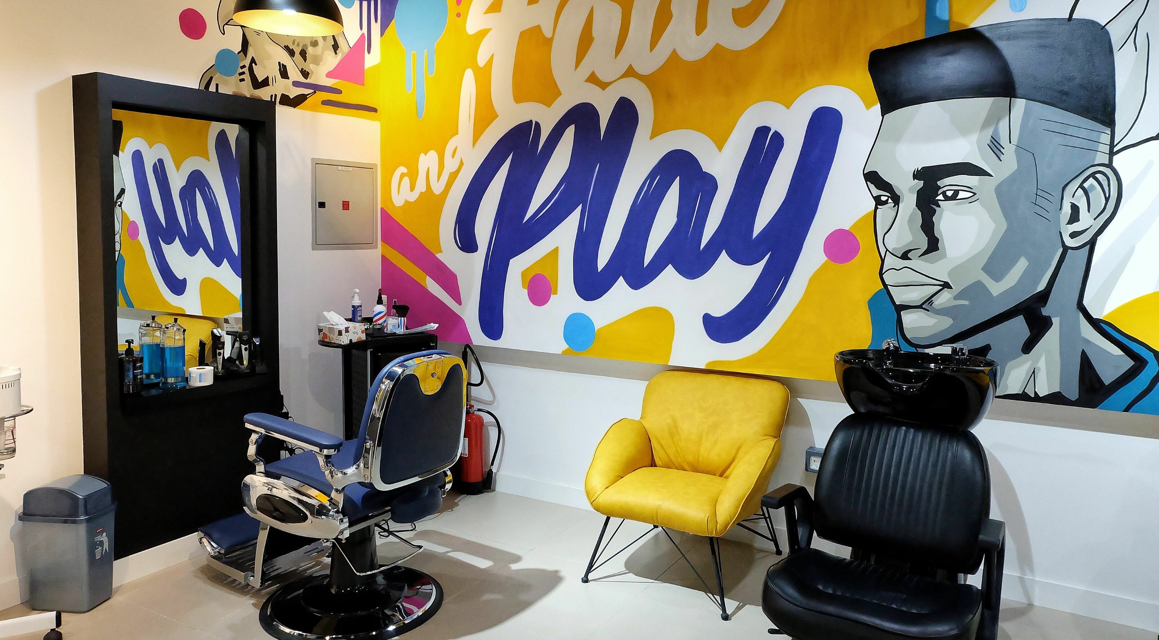 Modern barbershop interior at Fade & Play - Jumeirah 2, Dubai, Dubai, AE, featuring colorful wall art.