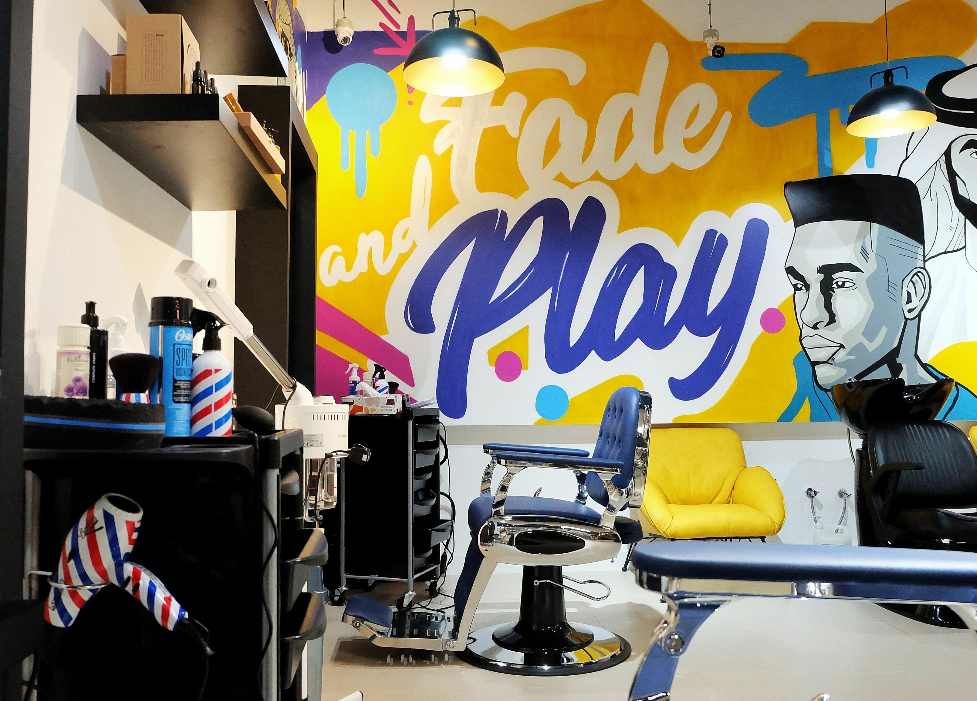 Colorful interior of Fade & Play - Jumeirah 2 salon in Dubai, Dubai, AE, with modern chairs and wall art.