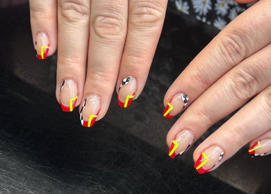 Bold nail art with red and yellow accents, crafted at Amelia boutique, Carlton In Lindrick, England, GB.