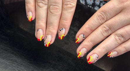 Bold nail art with red and yellow accents, crafted at Amelia boutique, Carlton In Lindrick, England, GB.