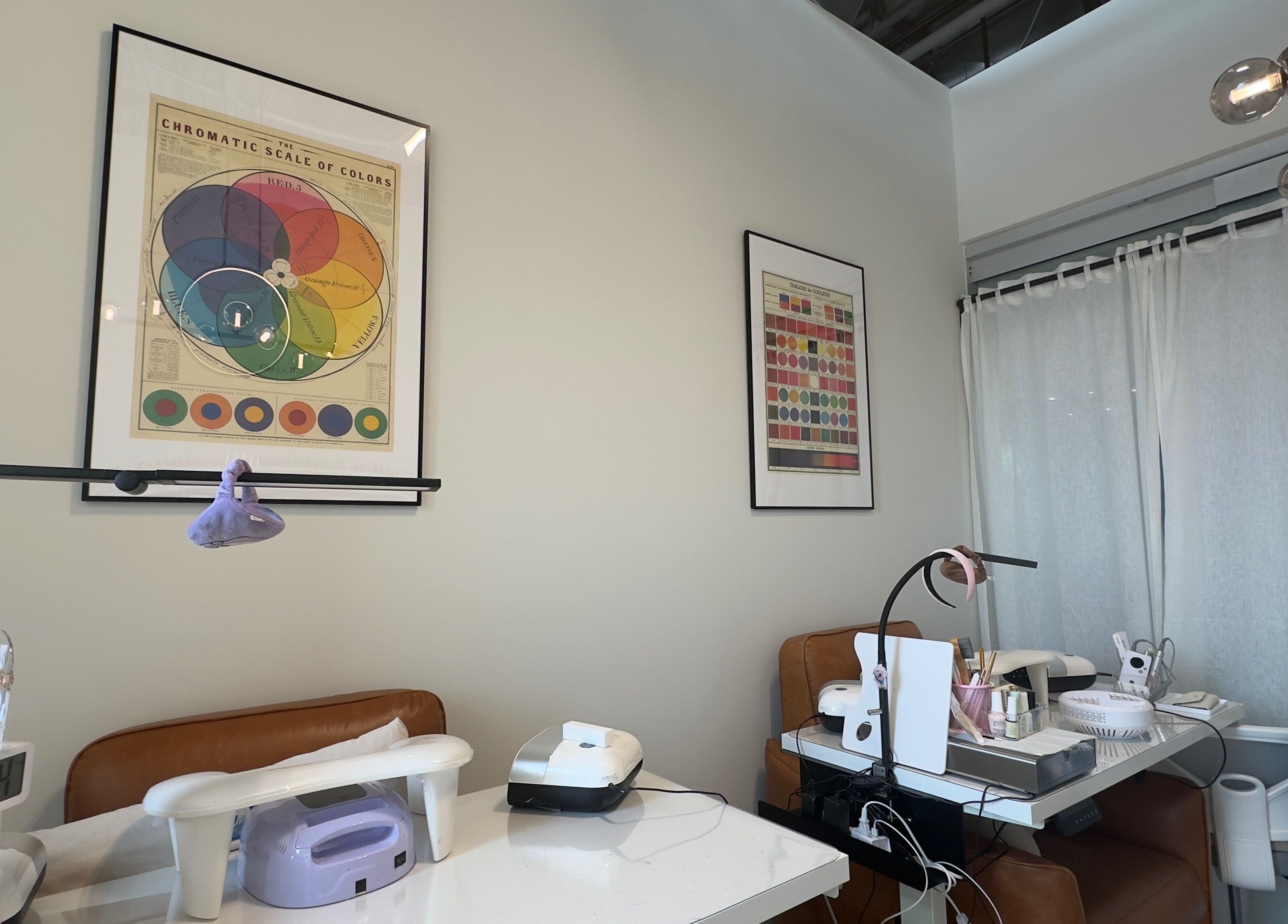 Jennie Nail Studio in Markham, Ontario, CA with modern decor and nail tables under vibrant color charts.