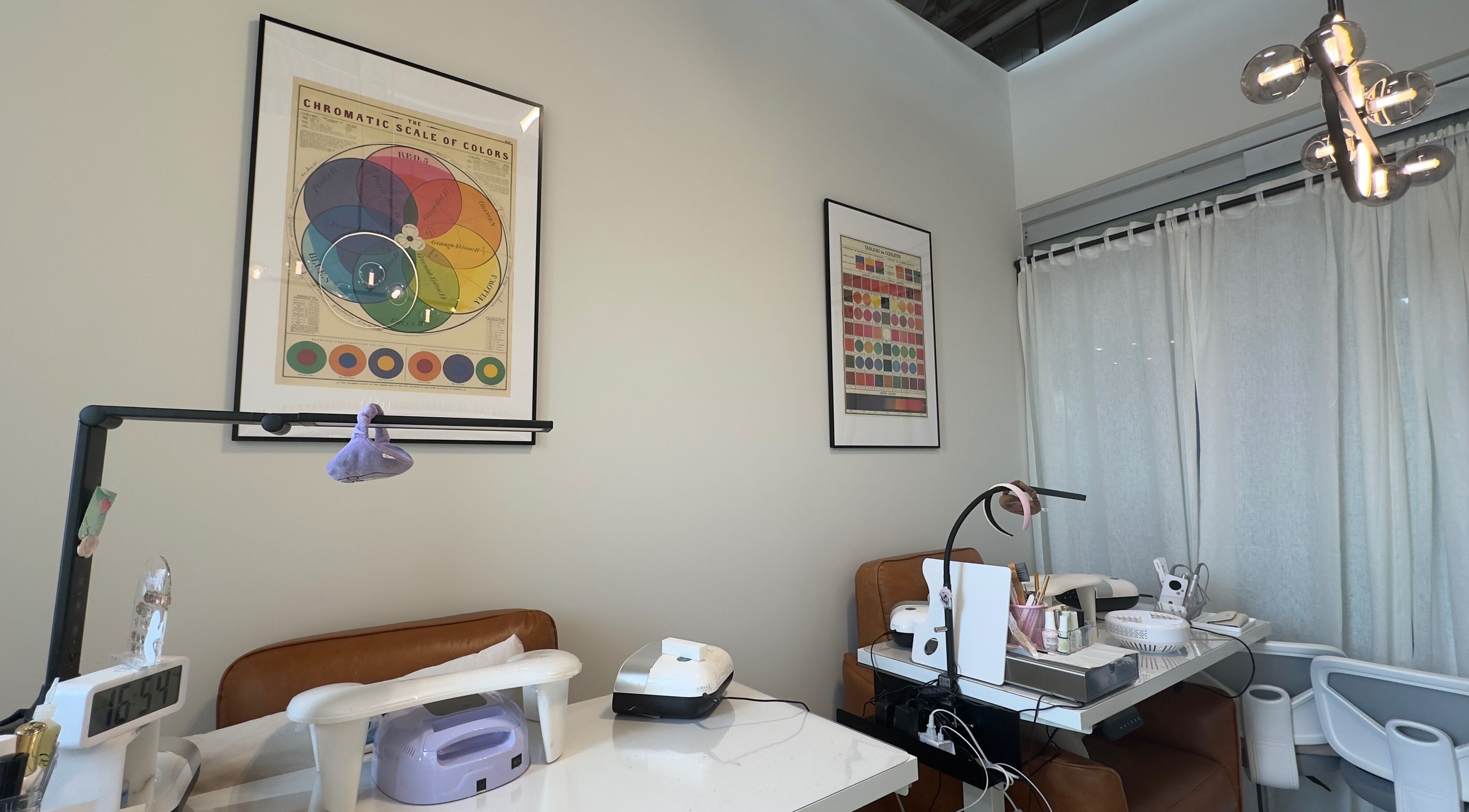 Jennie Nail Studio in Markham, Ontario, CA with modern decor and nail tables under vibrant color charts.