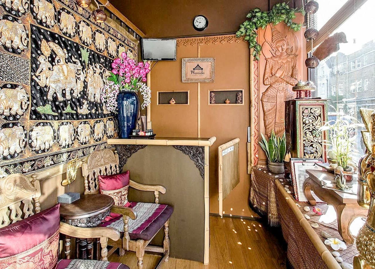 Elegant Thai-style decor at Wanida Thai Spa Ltd, London, England, GB, featuring intricate wood carvings and rich textiles.