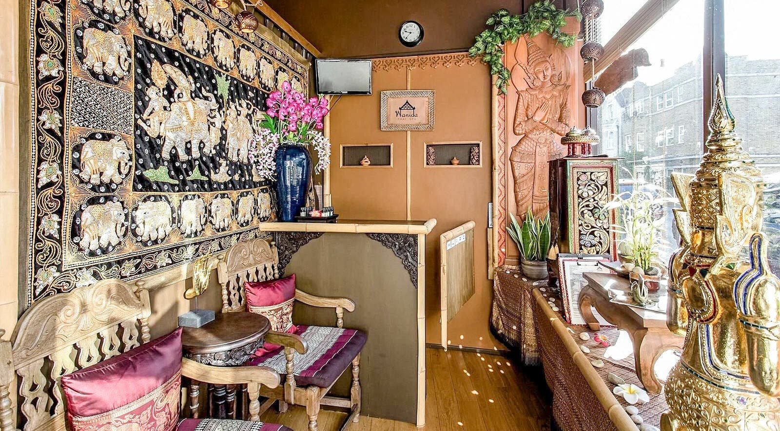 Elegant Thai-style decor at Wanida Thai Spa Ltd, London, England, GB, featuring intricate wood carvings and rich textiles.