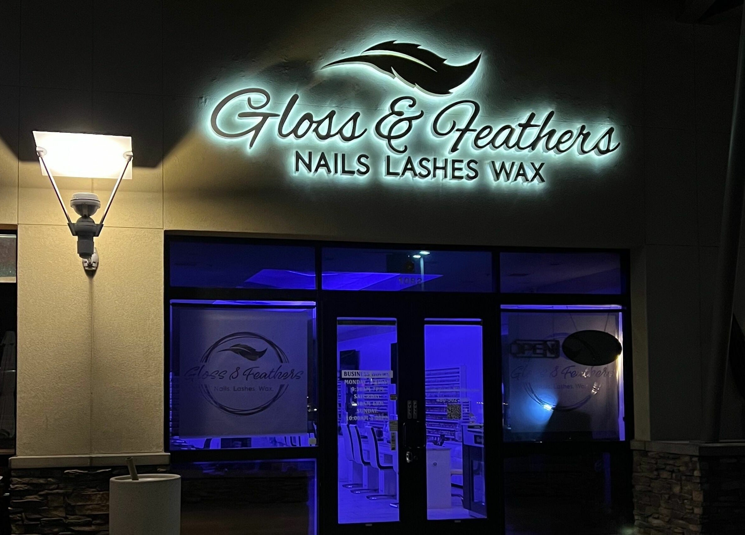 Gloss and Feathers (Nails. Lashes. Wax.) entrance in Phoenix, Arizona, US, illuminated at night.