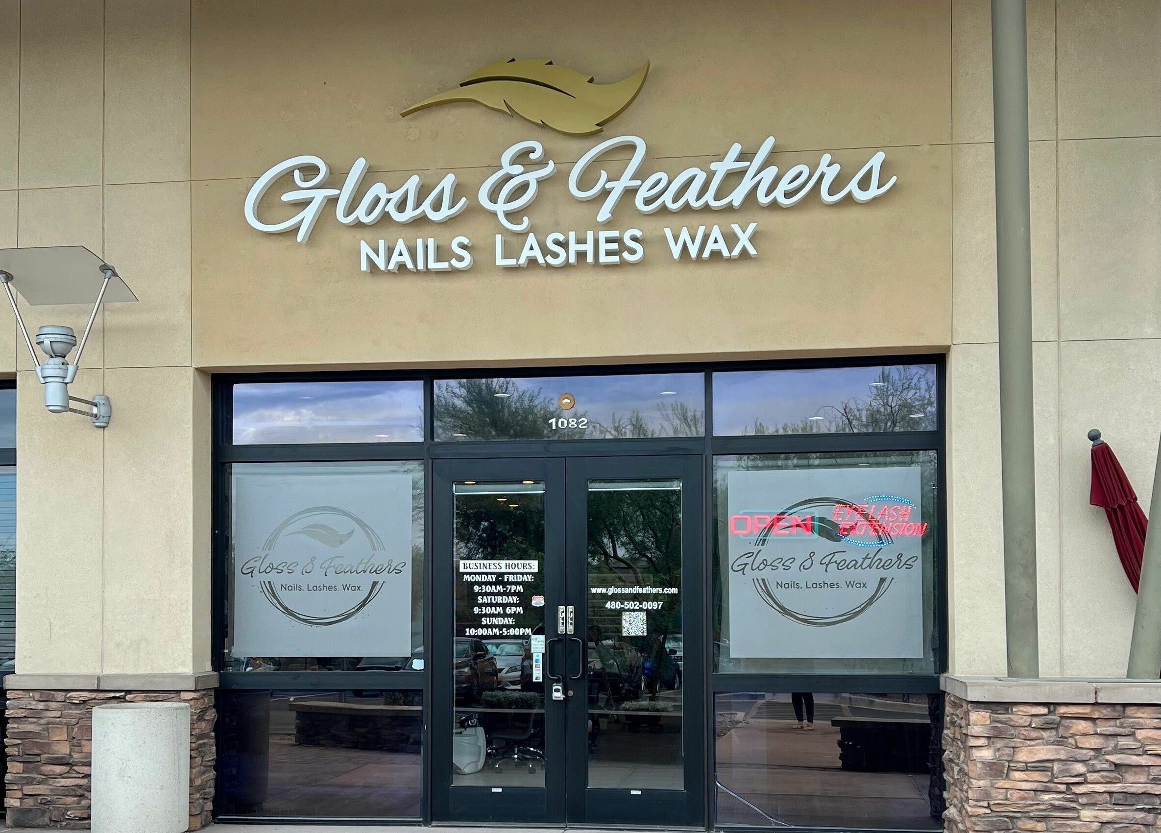 Entrance of Gloss and Feathers (Nails. Lashes. Wax.) in Phoenix, Arizona, US, showcasing modern storefront signage.