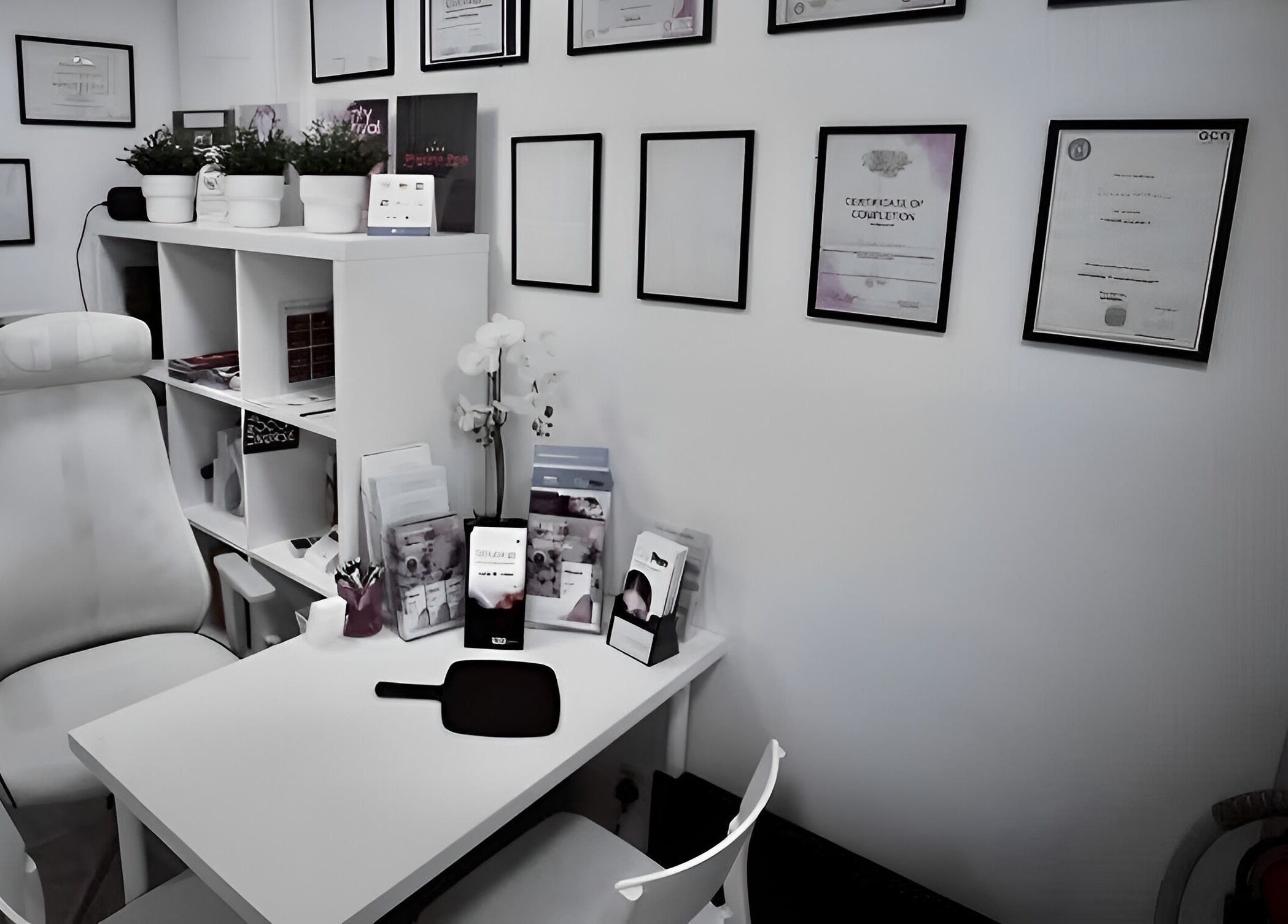 Treatment room at Smoothlines Facial Aesthetics in Stockport, England, GB, showcasing certifications and equipment.