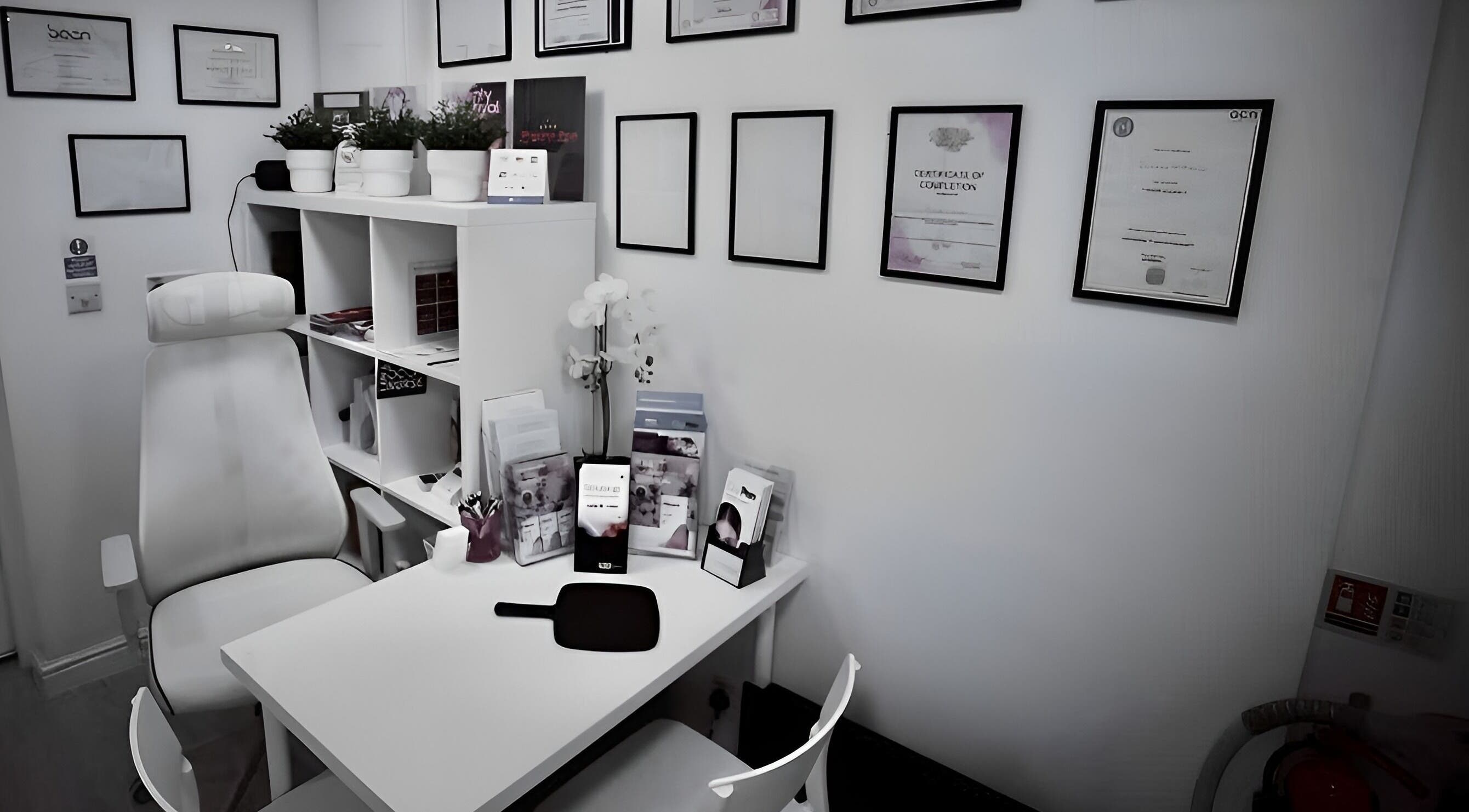 Treatment room at Smoothlines Facial Aesthetics in Stockport, England, GB, showcasing certifications and equipment.