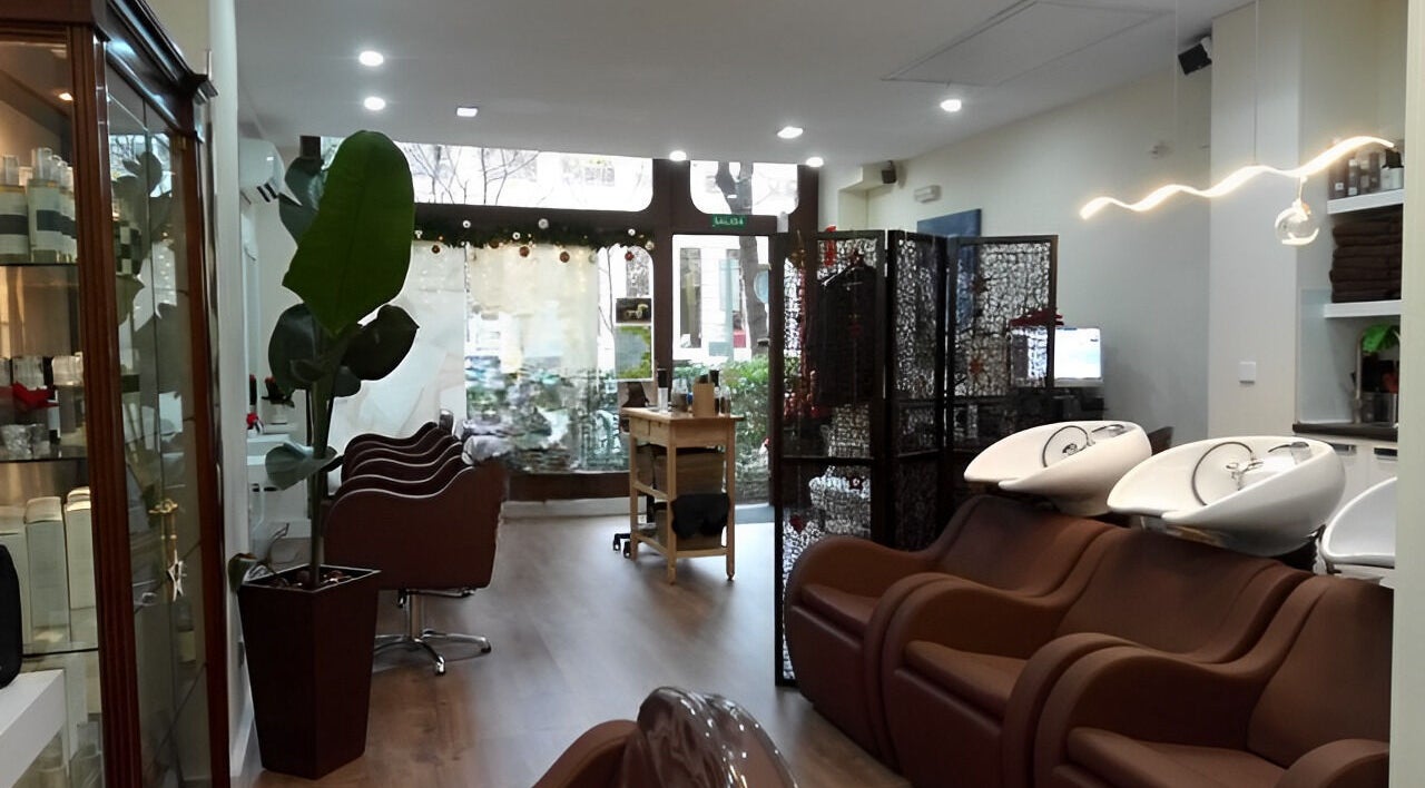 Interior moderno de Rytuals Peluqueros en Madrid, Comunidad de Madrid, ES, con sillas cómodas y lavabos elegantes.