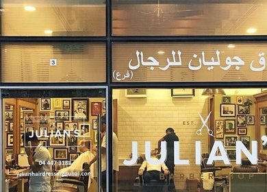Front of Julian's Barbershop in Dubai, AE at evening with illuminated interior visible.