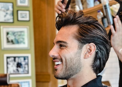 Man enjoying haircut at Julian's Barbershop, Dubai, AE.