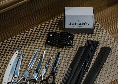 Hairdressing tools at Julian's Barbershop, Dubai, AE, showcasing scissors and combs on a wooden counter.
