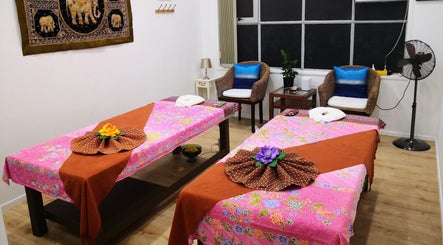 Cozy massage room at Surin Thai Spa, Auckland, NZ, with vibrant decorated beds and serene ambiance.