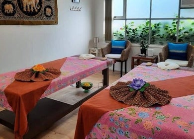 Serene massage room at Surin Thai Spa, Auckland, NZ with two decorated tables.
